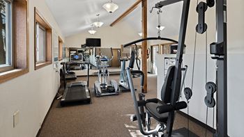a gym with cardio machines and weights on the floor